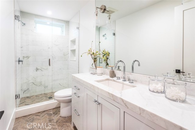 Basement bathroom completed in neolith quartz, herringbone textured limestone floor and Carrara marble shower