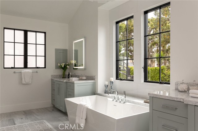 Master bathroom with a gorgeous marble pattern in the center of the marble flooring , dual sinks separated by the soak in tub, Makeup Vanity in the huge to die for walk in closet