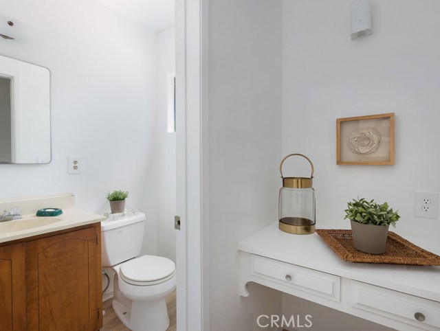Small powder bath with vanity right off kitchen/dining area.