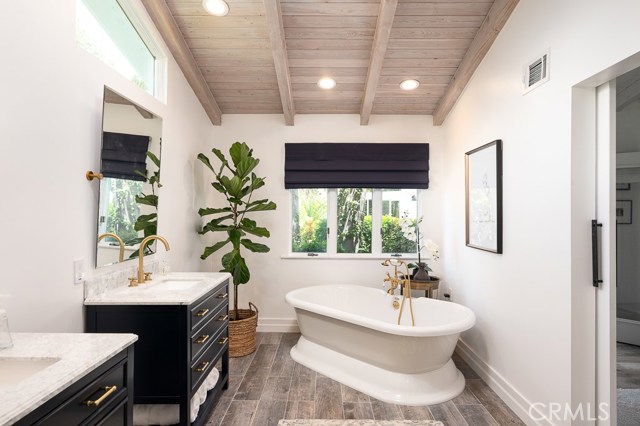 Spacious remodeled master bath with custom shower and freestanding soaking tub.