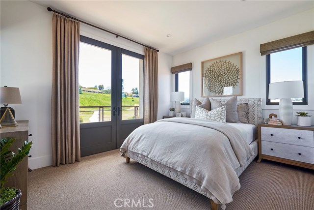 Upstairs bedroom suite with balcony & French doors, near bonus room. Model home shown.