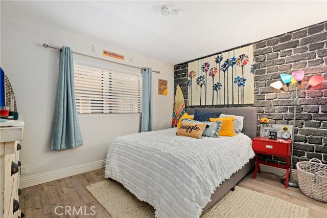 Second bedroom with brick wallpaper statement wall.