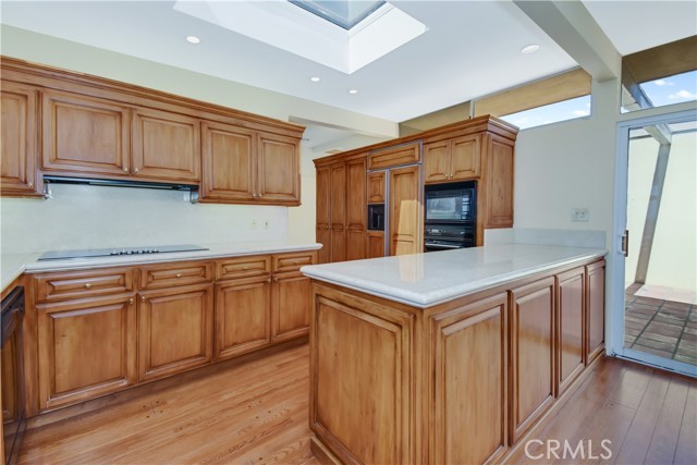 Upgraded Kitchen with beautiful cabinets, counters skylight and wood floors