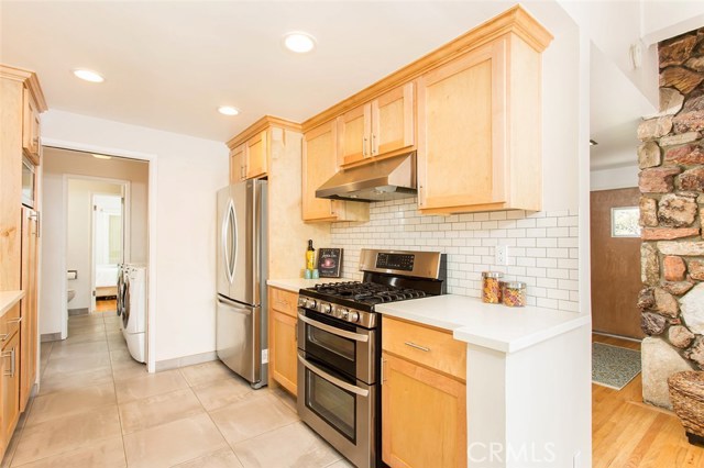 View into kitchen, laundry room and 3/4 bathroom.  View of front door behind fireplace.