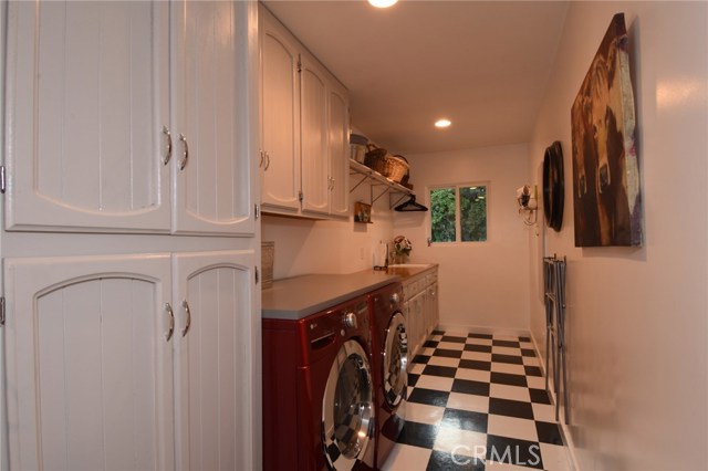 Perfect mud room connects the house to the garage!  Tons of storage, counter space, sink area, and poles to hang your drying clothes!  There is even a built-in ironing board on the wall (new version, of course!)