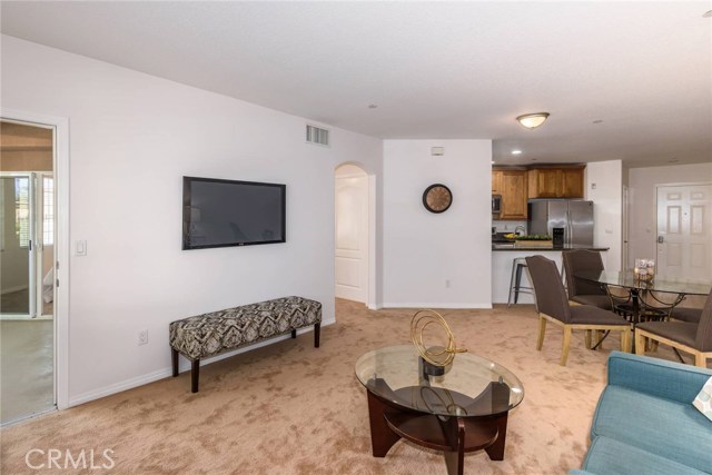 View of living room with door to patio on left and entrance to bedroom in the center.