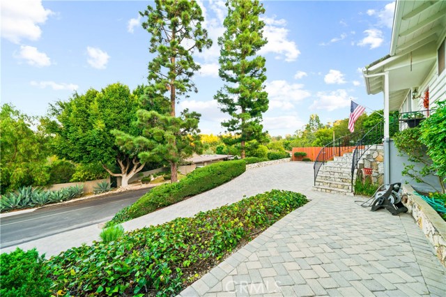 View of the driveway, front yard and entry stairs that lead to the front door.