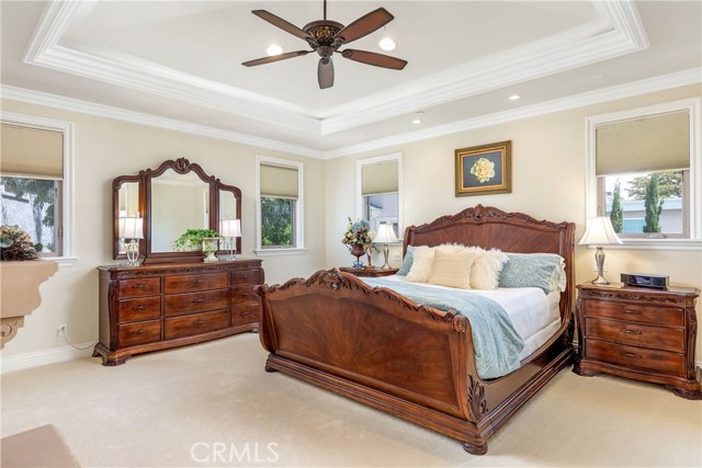Main suite with fireplace, high, coffered ceiling and accent lighting.