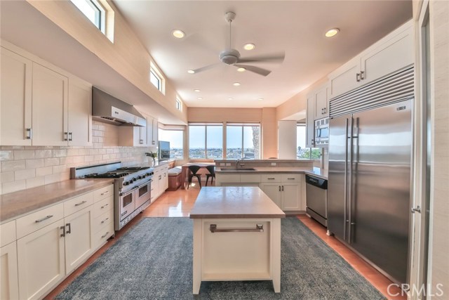 remodeled kitchen with new island cabinet, new counters, sink, back-splash and wallpaper. New water filter