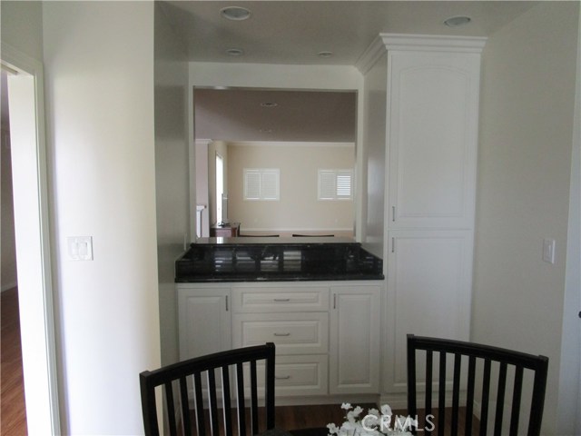 Storage in breakfast room with black granite.