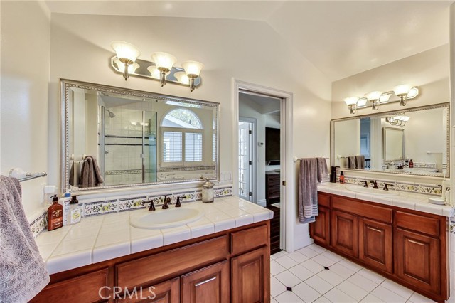 This view of en-suite bathroom is looking out towards main hallway. 2 large vanity counters provide each their own "space".  Walk-in closet is to left of picture.