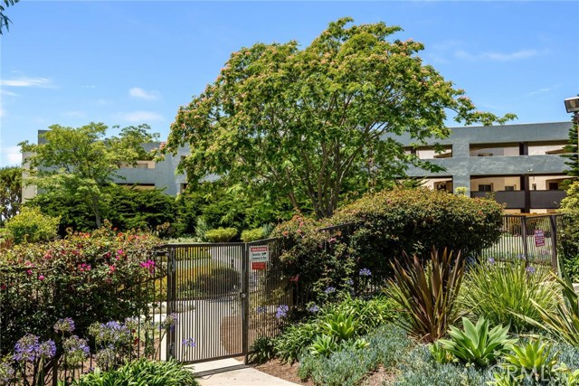 Gate near tennis courts and large guest parking lot.