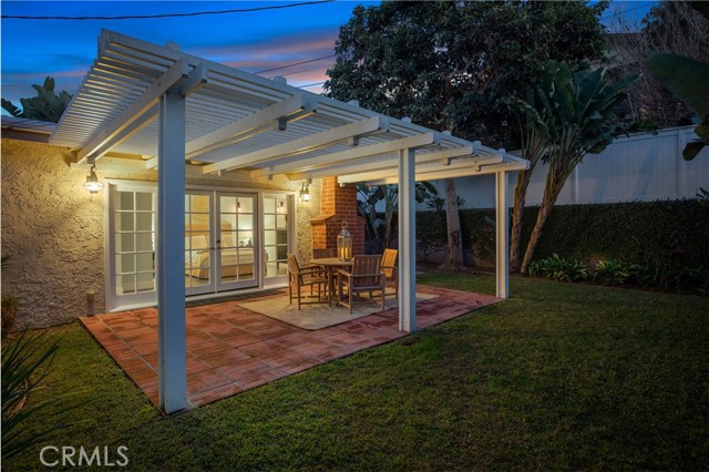 The lush and tranquil backyard with patio and pergola.