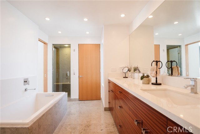 Primary bathroom includes private WC, soaking tub, double vanities, quartz counters and African mahogany wood cabinets.