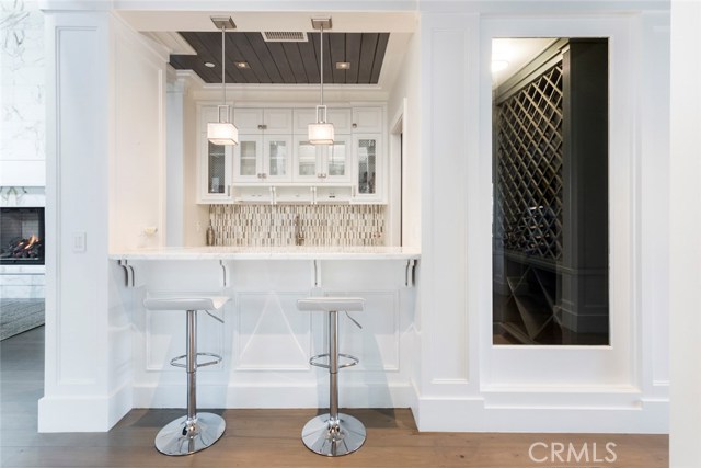 Bar, wine fridge, and 100 bottle wine cellar