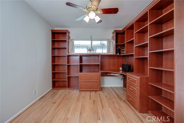 Office with built in desk & shelves and a closet with sliding doors