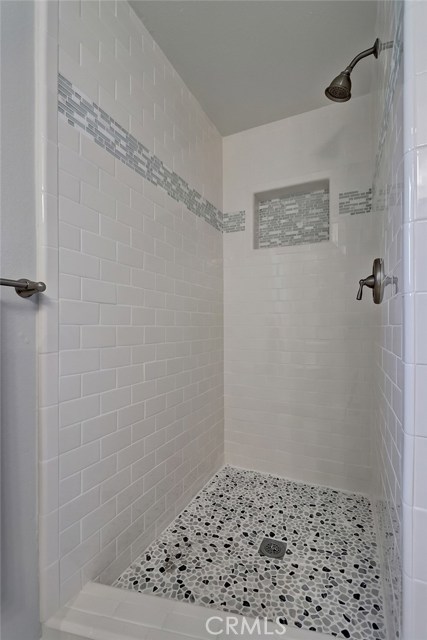 Secondary bath with tile surround in neutral fresh shades.