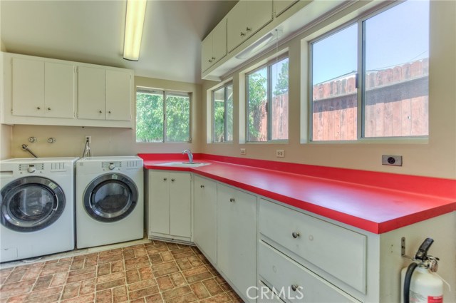 Huge laundry room with washer, dryer , utility sink, counter space and storage cabinets