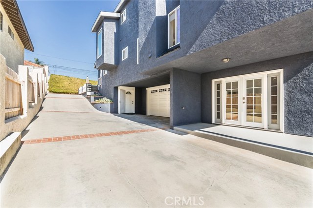 view of driveway, garage, and downstairs bedroom/gym