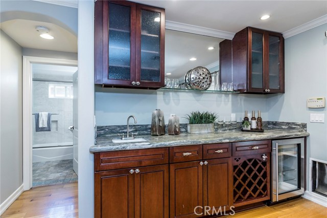 Beautiful, granite covered built-in wet bar with beverage refrigerator and wine storage.