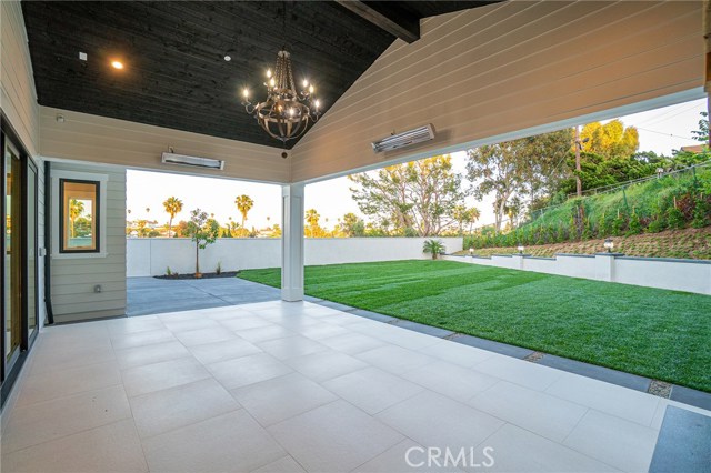 View of covered patio and expansive backyard area from 20 foot sliding doors in family room.