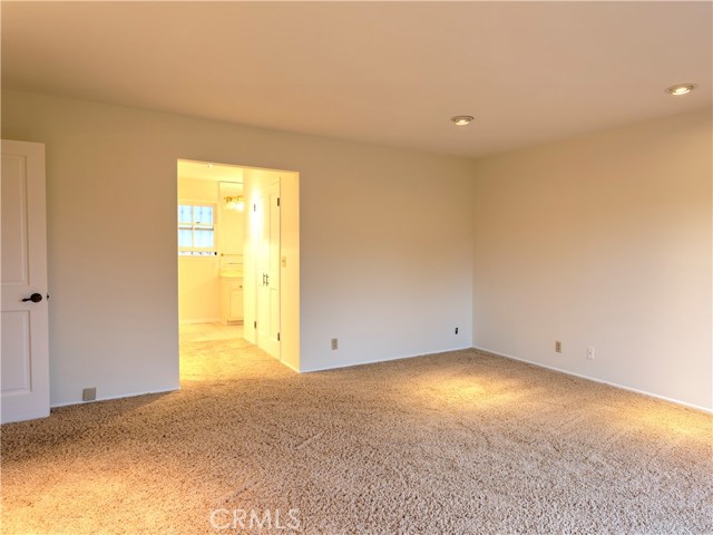 Large master suite with walk-in closet and small balcony over backyard