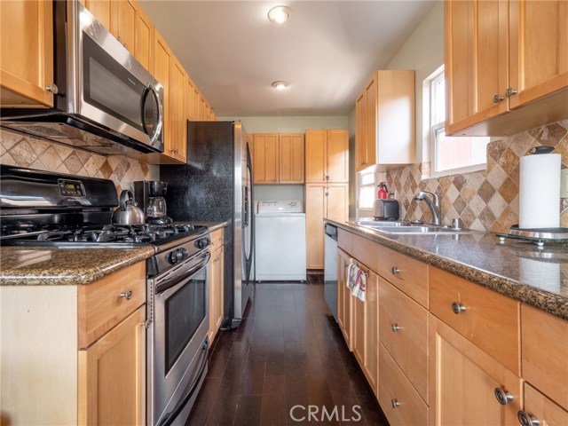 Enjoy cooking on gas range, new microwave, fridge included!  Also, door is located at the end, accessing the side of the house, and quick access to the BBQ in the backyard.