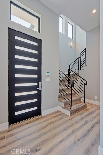 LOOKING FROM THE LIVING ROOM TOWARDS THE FRONT DOOR AND STAIR WAY TO THE SECOND. TWELVE FOOT CEILINGS ON THE FIRST FLOOR.