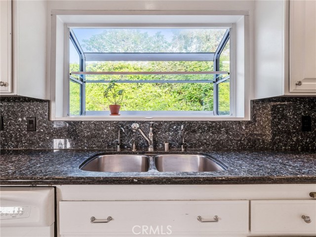 The kitchen offers clean and stylish white cabinetry, granite counter tops, with an ample countertop space.