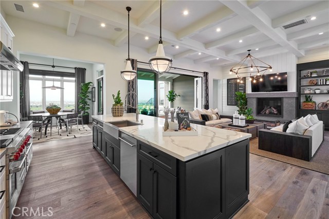 Gorgeous gourmet kitchen, dining nook, great room, and covered patio open to the views across the back yard. Model home shown.