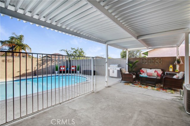 This spacious patio area has a freshly painted solid patio cover, block walls for privacy, with a fenced off pool area.