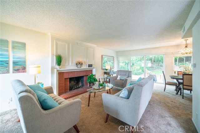 Formal Living room has a beautiful brick fireplace and mantel with large sliders to bring in natural light.