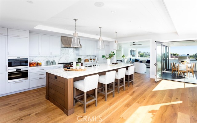 Kitchen with 12 foot island in Walnut wood ( easily fits 6 chairs) Island has hidden storage. Neolith Quartz counters and backsplash