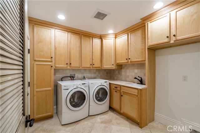 Laundry Room with space for a second refrigerator. Access to walk-in Utility closet which houses residential elevator control unit.