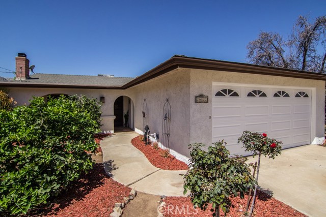 FRONT OF HOME WITH FRUIT TREES AND ROSE BUSH.