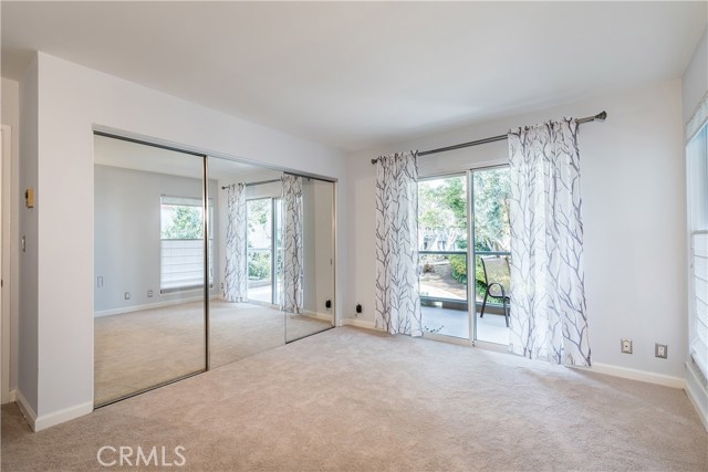 Good-sized bedroom with access to the balcony & another tree-view window.