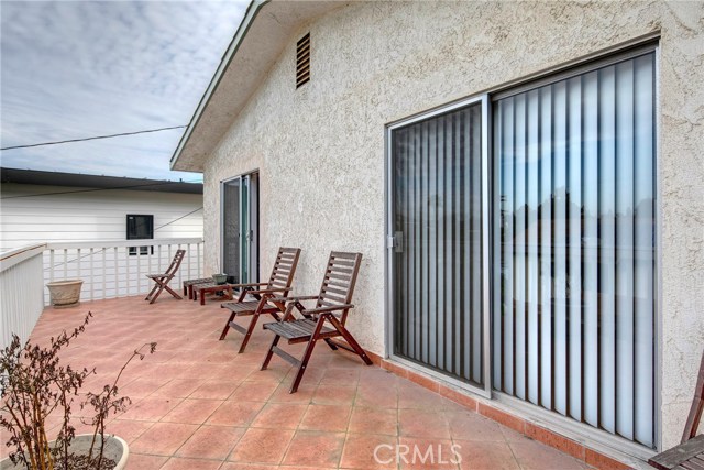 Huge balcony with dual bedroom access and overlooking the backyard and sparkling pool.