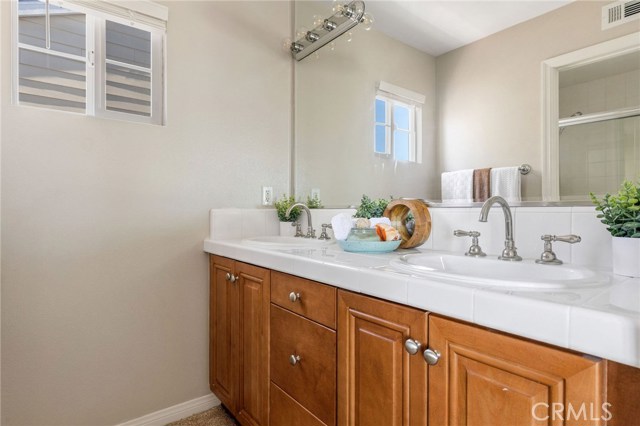 Primary suite bathroom with dual sinks and plenty of storage. [upstairs]