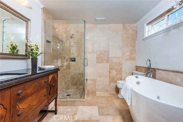 Lovely ensuite bathroom upstairs with jetted bathtub, stone shower and antique vanity.