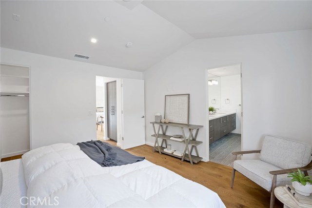 Master bedroom with hardwood flooring, walk-in closet