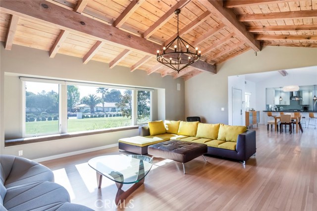 The living room features richly finished open beams that create a warmth and complimented by the stone-set fireplace.