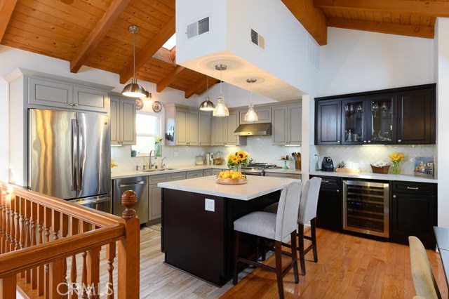 Open kitchen with center island, wine bar, stainless steel appliances, and wine bar - one of the many upgrades done in recent years totaling over $150,000.