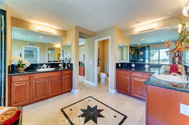 Master bathroom showcases travertine stone with Italian granite inlays, vanity, bathtub and walk-in shower