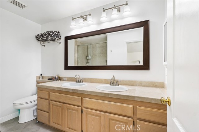 Double vanity master bath with tile counters and floors