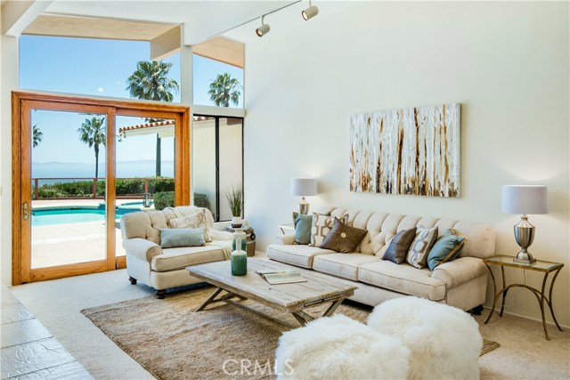 Living room with a view of Catalina and the pool features a fireplace and 7.5 foot sliding glass doors that bring the outside in.