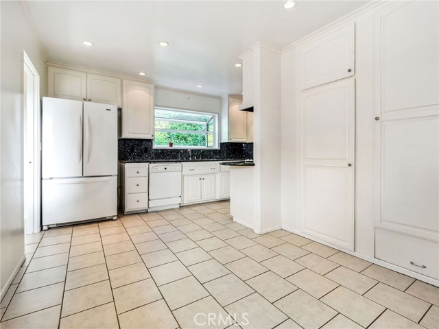 The kitchen with a large breakfast nook and ample cabinetry and pantry space.