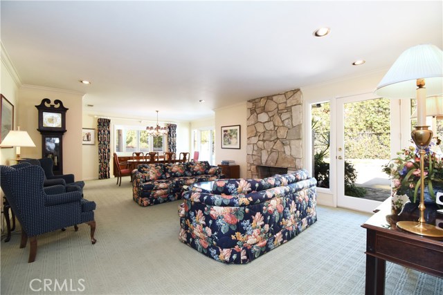 Formal living room with PV stone fireplace and 2 french doors leading to yard/pool. Recessed lighting, crown molding, grandfather clock.