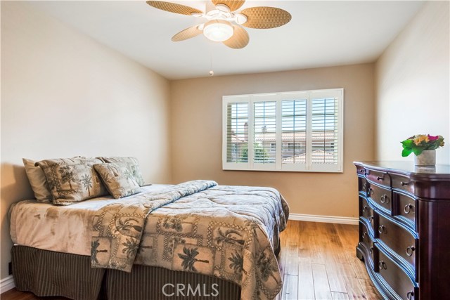 Bedroom #3 with hardwood floors, ceiling fan and shutters