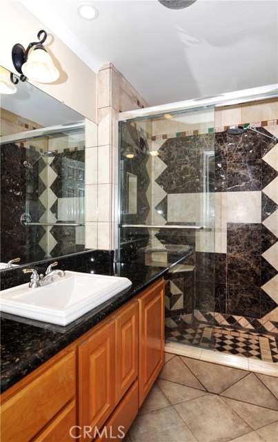 Guest bathroom with designer sink and walk in shower, Maple cabinets and granite counters.