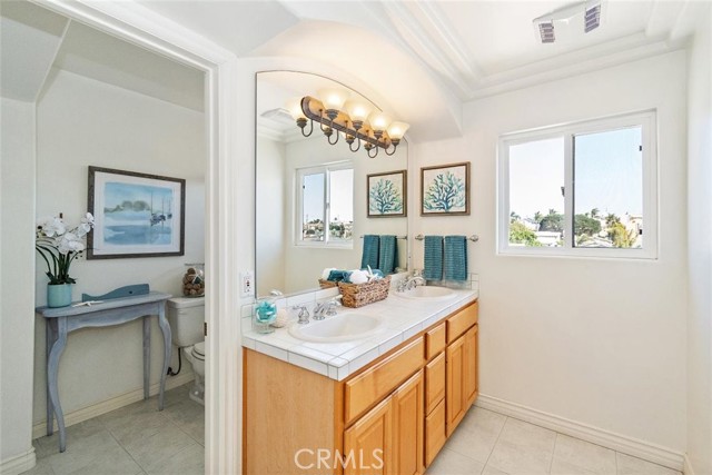 Upstairs shared bathroom with double sinks and door to separate the room with the toilet, bath and shower.